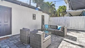 A patio with wicker furniture, a white picket fence, and a door to a building. - 2 Conjoined Units - Steps From Madeira Beach! (Madeira Beach)