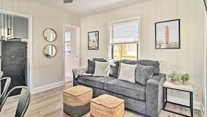 A living room with a grey sofa, two round mirrors, and a framed picture on the wall. - 2 Conjoined Units - Steps From Madeira Beach! (Madeira Beach)