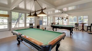 A pool hall with multiple pool tables, overhead lighting, and large windows. - Resort Pool & Sports Courts! Port Charlotte Home (Port Charlotte)