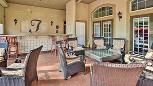 A spacious patio area with wicker furniture, a glass-top table, and a ceiling fan. - 10 Mi to Disney: Davenport Condo w/ Pool Access! (Davenport)
