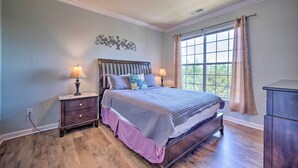 A bedroom with a large bed, two bedside tables, a dresser, and a window with curtains. - 10 Mi to Disney: Davenport Condo w/ Pool Access! (Davenport)