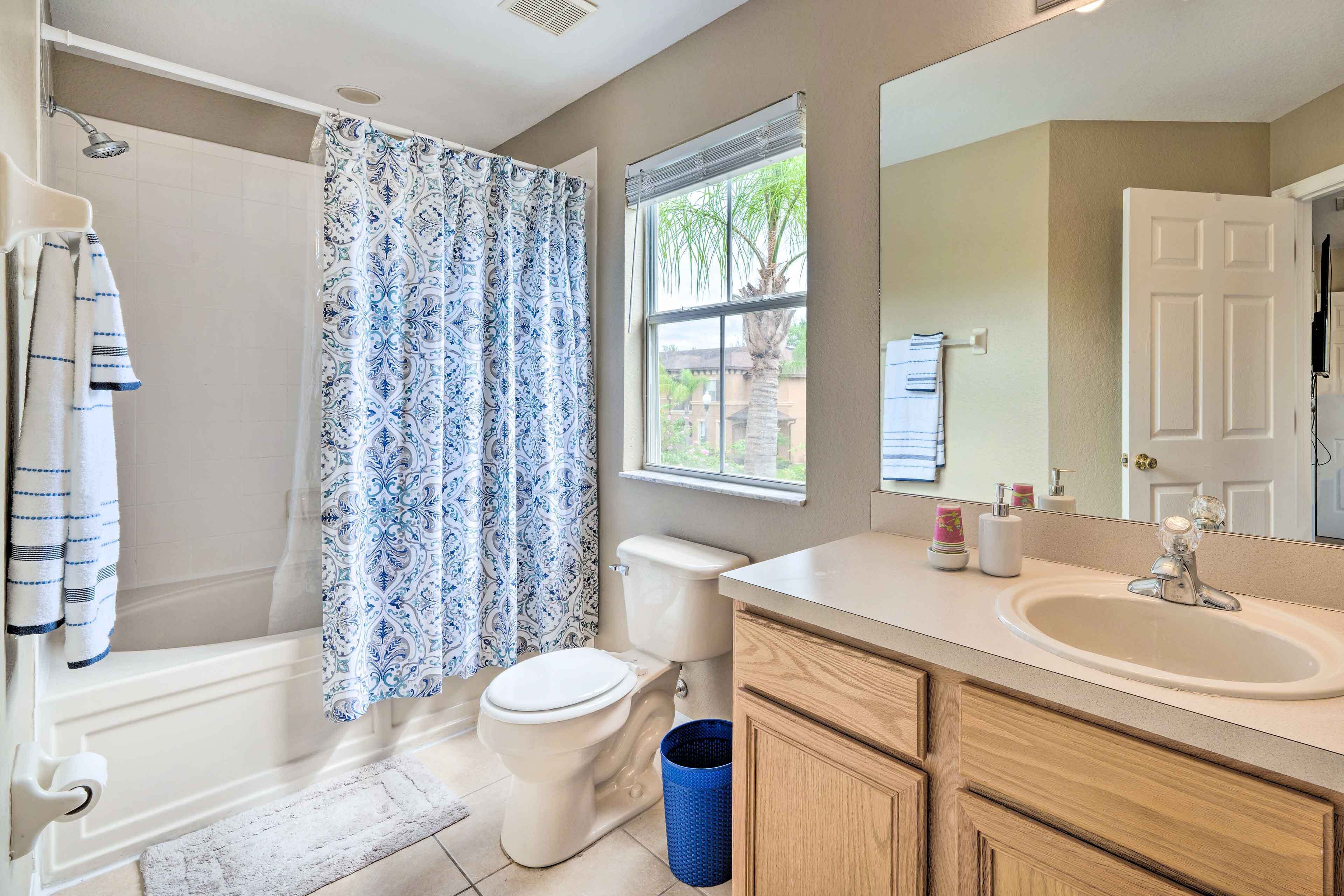 A bathroom with a bathtub, toilet, and sink.
