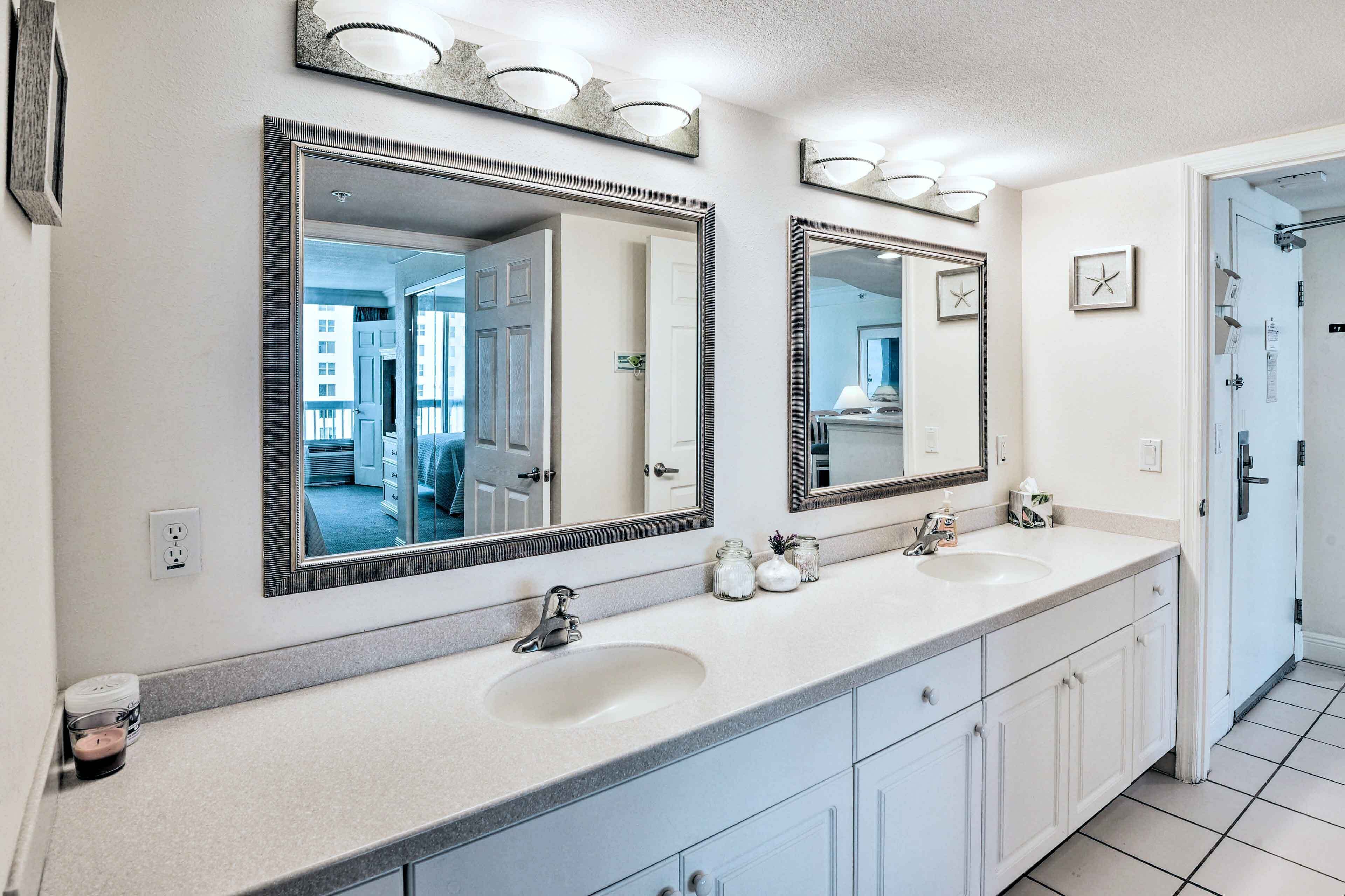 A bathroom with two sinks, large mirrors, and a tiled floor.