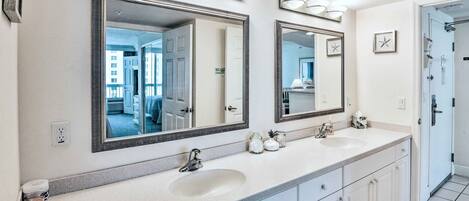 A bathroom with two sinks, large mirrors, and a tiled floor.