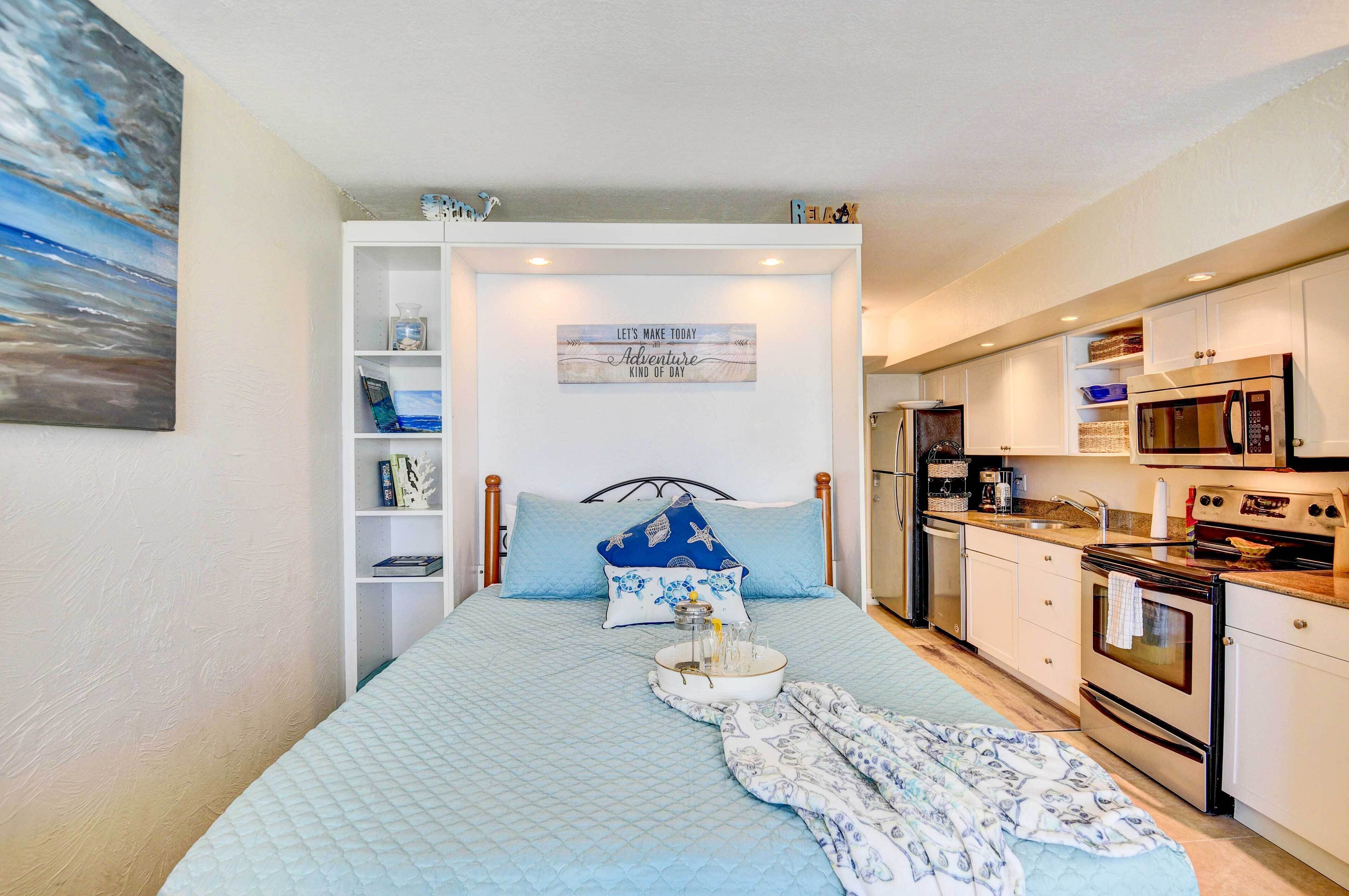 Un dormitorio con una cama, una mesita de noche y un velador. Se ve una ventana con vistas al exterior.