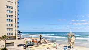 A beachfront hotel with a pool, a lifeguard tower, and a parking area. - Daytona Beach Studio With Balcony + Ocean View (Daytona Beach Shores)