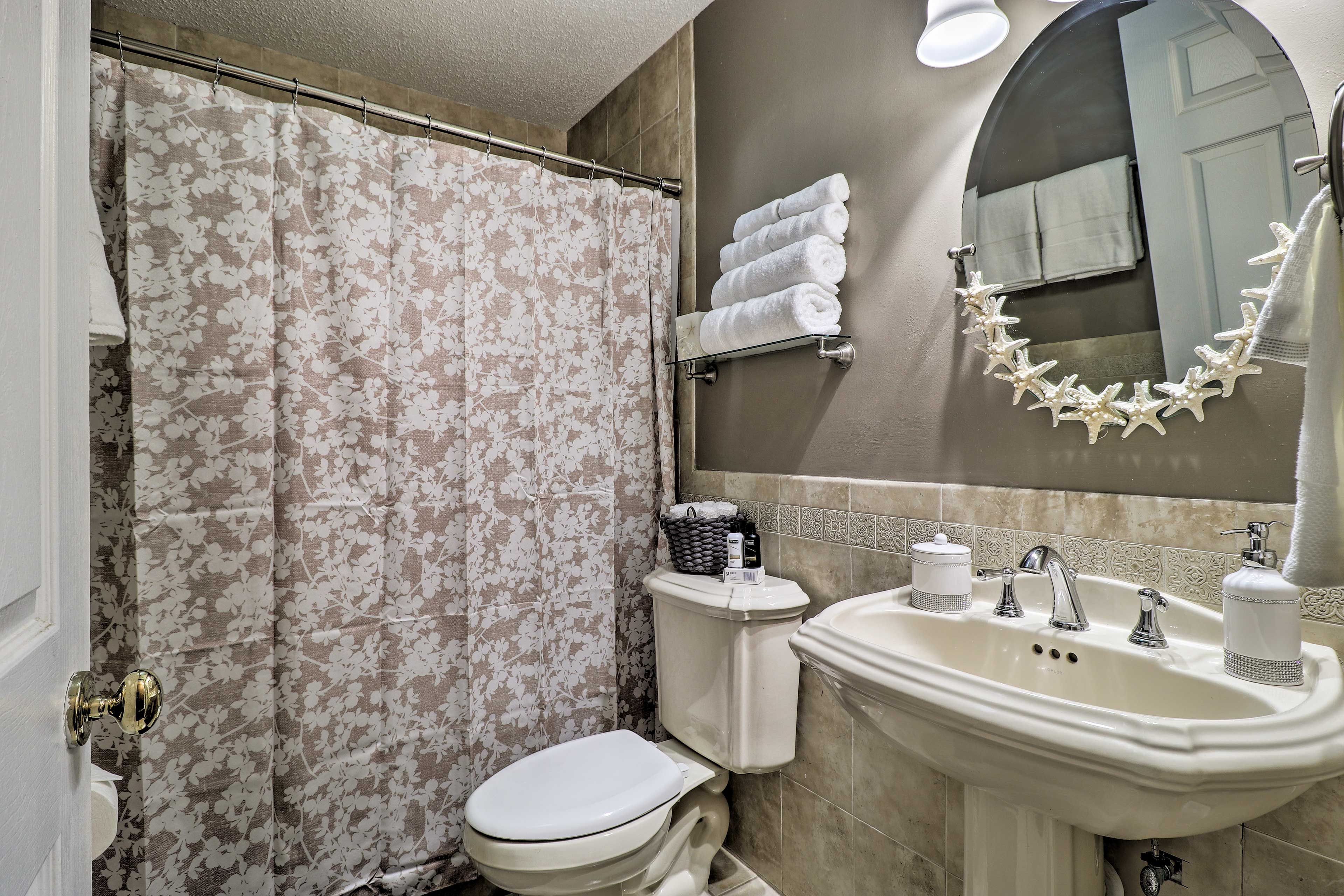 Une salle de bain équipée de toilettes, d’un lavabo et d’un rideau de douche.