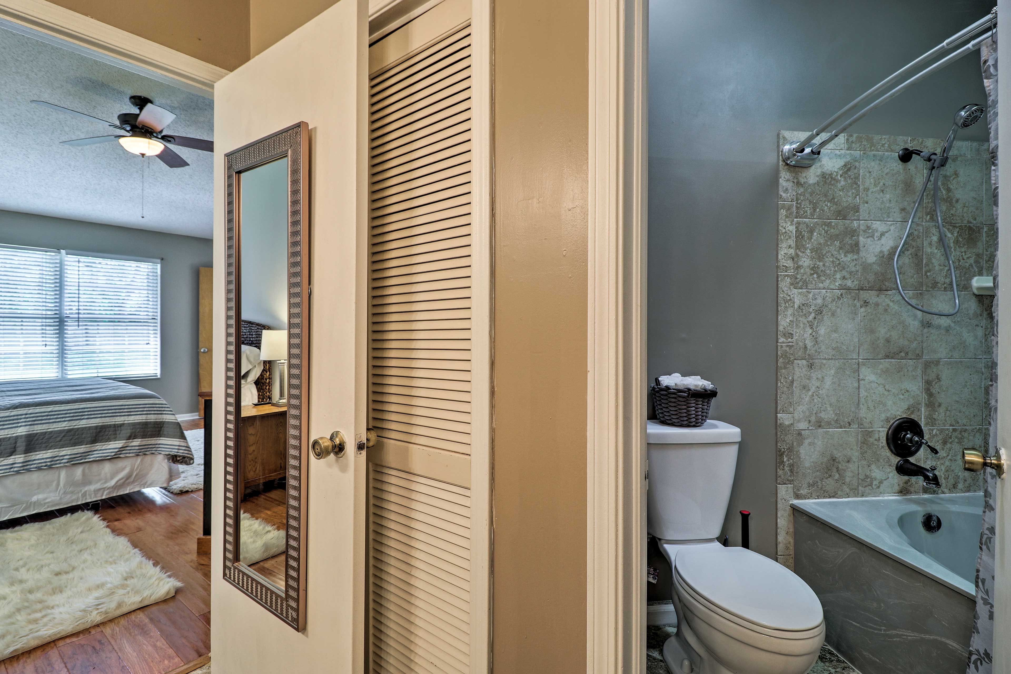 A bathroom with a shower, toilet, and a bathtub.