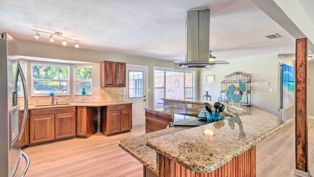 A spacious kitchen with granite countertops, wooden cabinets, and a large island. - Family Home w/ Private Pool & Fenced Yard! (Fort Walton Beach)