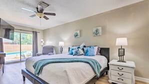 A bedroom with a bed, bedside lamps, a nightstand, and a ceiling fan. - Family Home w/ Private Pool & Fenced Yard! (Fort Walton Beach)