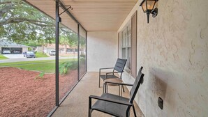 A covered porch with two chairs and a wall-mounted light fixture. - Family-friendly Ocala Retreat: 18 Mi to Dtwn! (Ocala)