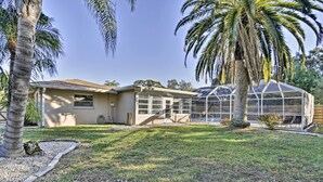 A house with a large glass greenhouse, a well-maintained lawn, and palm trees. - Florida Home 3 Mi to Siesta Key, Walk to Gulf Gate (Sarasota)