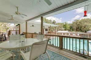 An outdoor deck with a pool, white furniture, and ceiling fans. - Pool Access: Homosassa Home Near Boat Launch! (Homosassa)