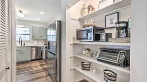 A modern kitchen with stainless steel appliances, white cabinetry, and a wooden floor. - 'green Acres' Home w/ Fire Pit + Fishing Pond (Molino)