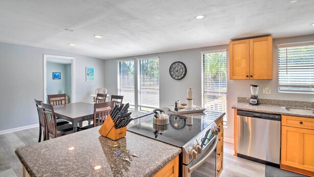 A modern kitchen with granite countertops, a built-in stove, and wooden cabinets.