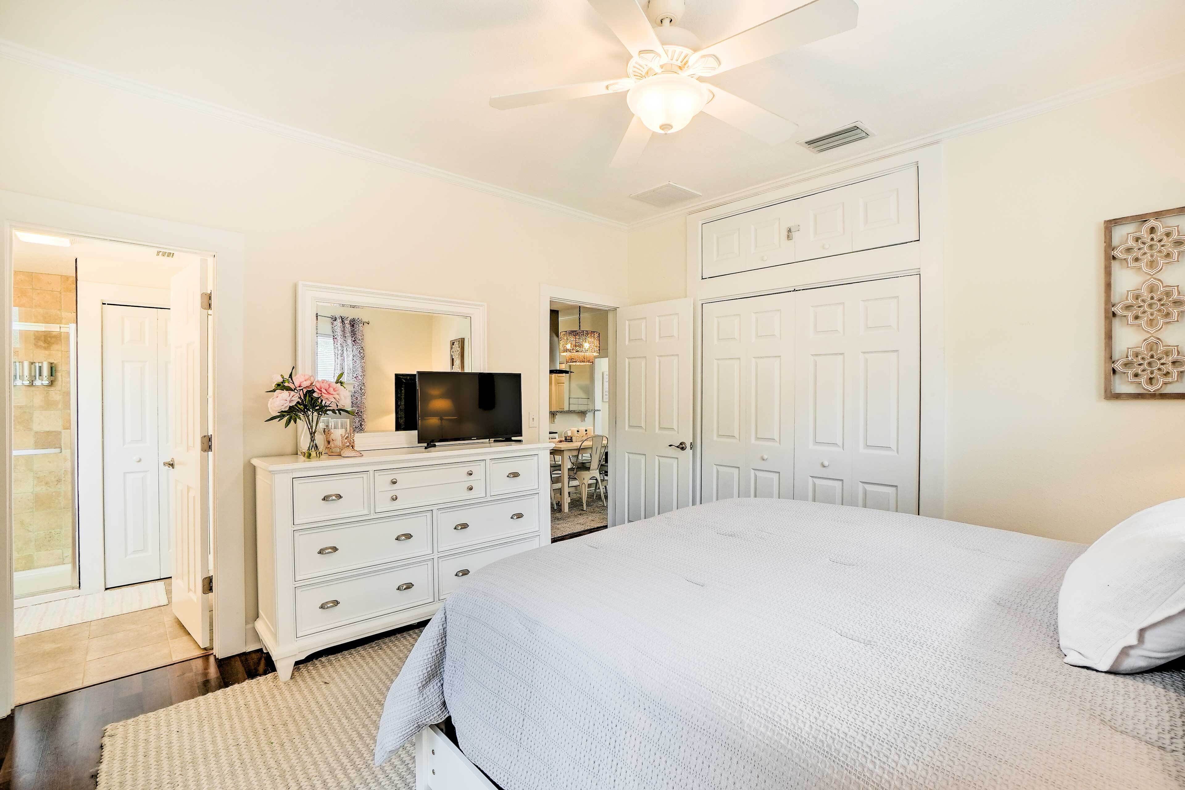 A bedroom with a bed, dresser, television, and wardrobe.