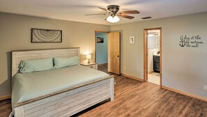 A bedroom with a wooden bed, a ceiling fan, a nightstand, and a wall with a motivational quote. - 20 Mi to UF Campus: Santa Fe Lake Escape w/ Dock! (Earleton)