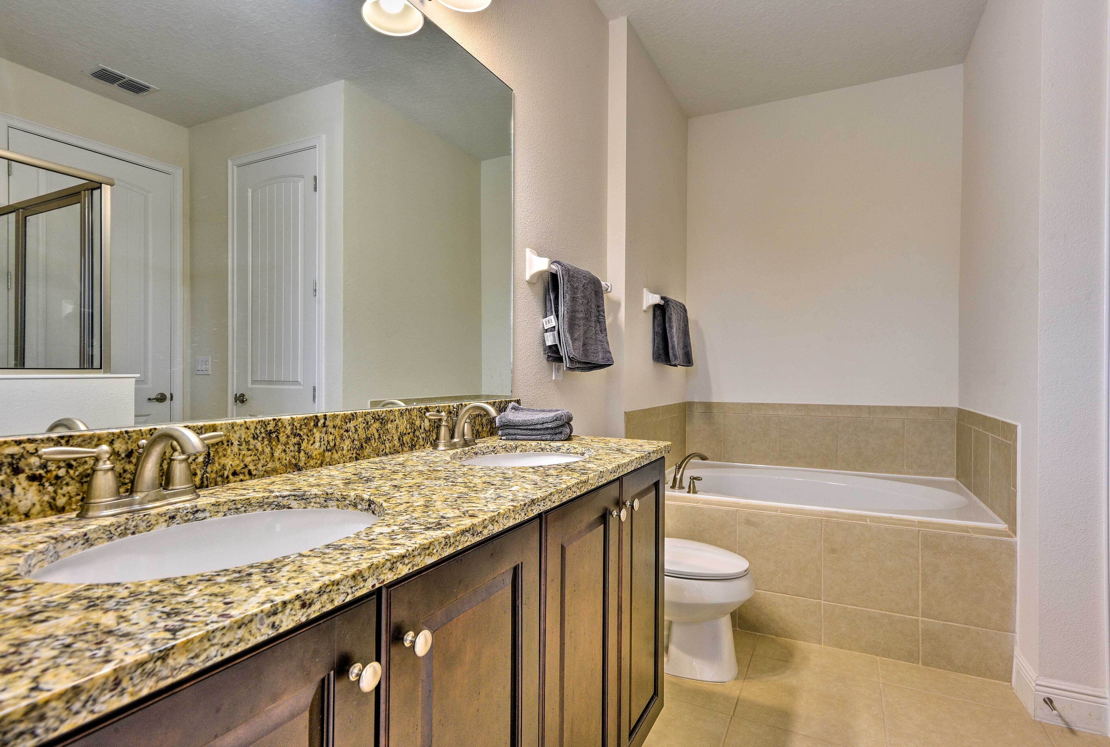 A bathroom with two sinks, a toilet, and a bathtub.