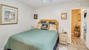 A bedroom with a bed, a nightstand, a ceiling fan, and a door leading to another room. - 5 Mi to Pensacola Beach: Townhome w/ Yard! (Gulf Breeze)