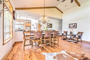 A spacious dining area with wooden flooring, a chandelier, and a cowhide rug. - House w/ Wraparound Porch, 1/2 Mi to Lake! (Lady Lake)