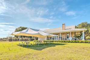 A covered outdoor area with picnic tables and a building with a porch. - House w/ Wraparound Porch, 1/2 Mi to Lake! (Lady Lake)