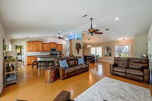 A spacious living area with a kitchen, dining space, and a seating area with a sofa and chairs.
