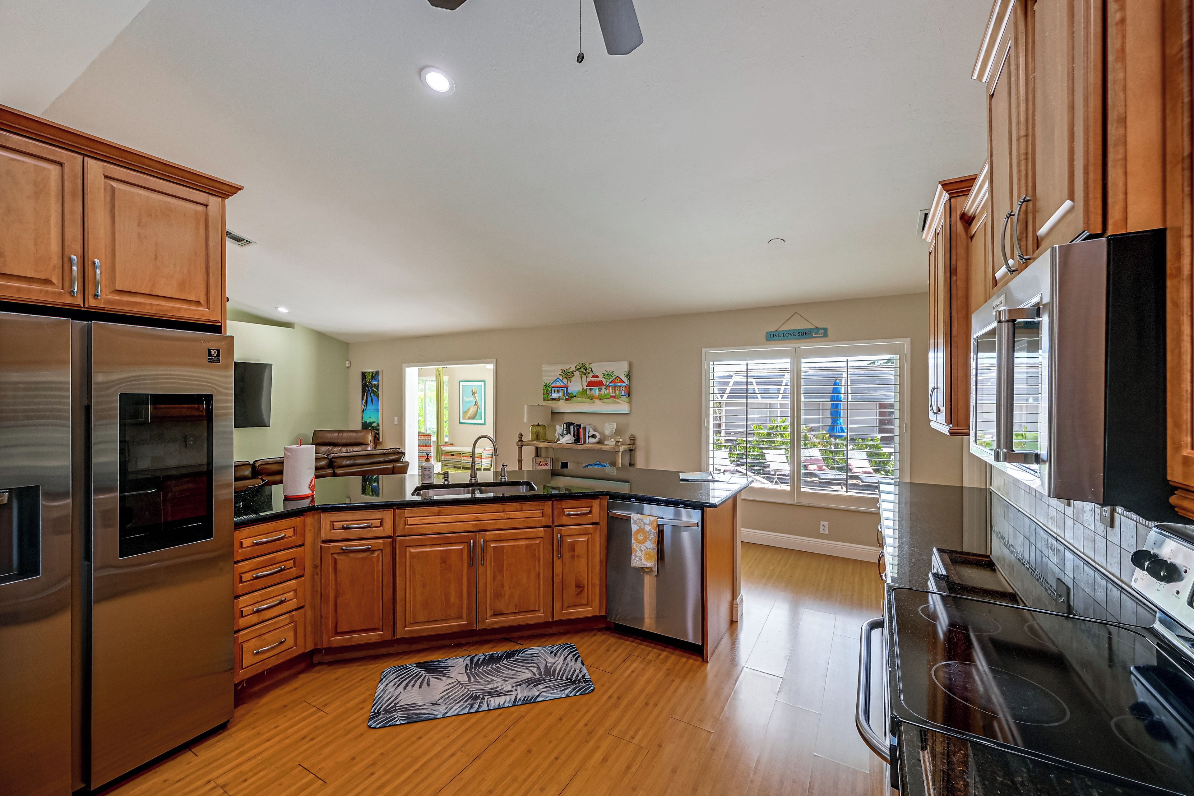 A modern kitchen with wooden cabinets, stainless steel appliances, and a large island.