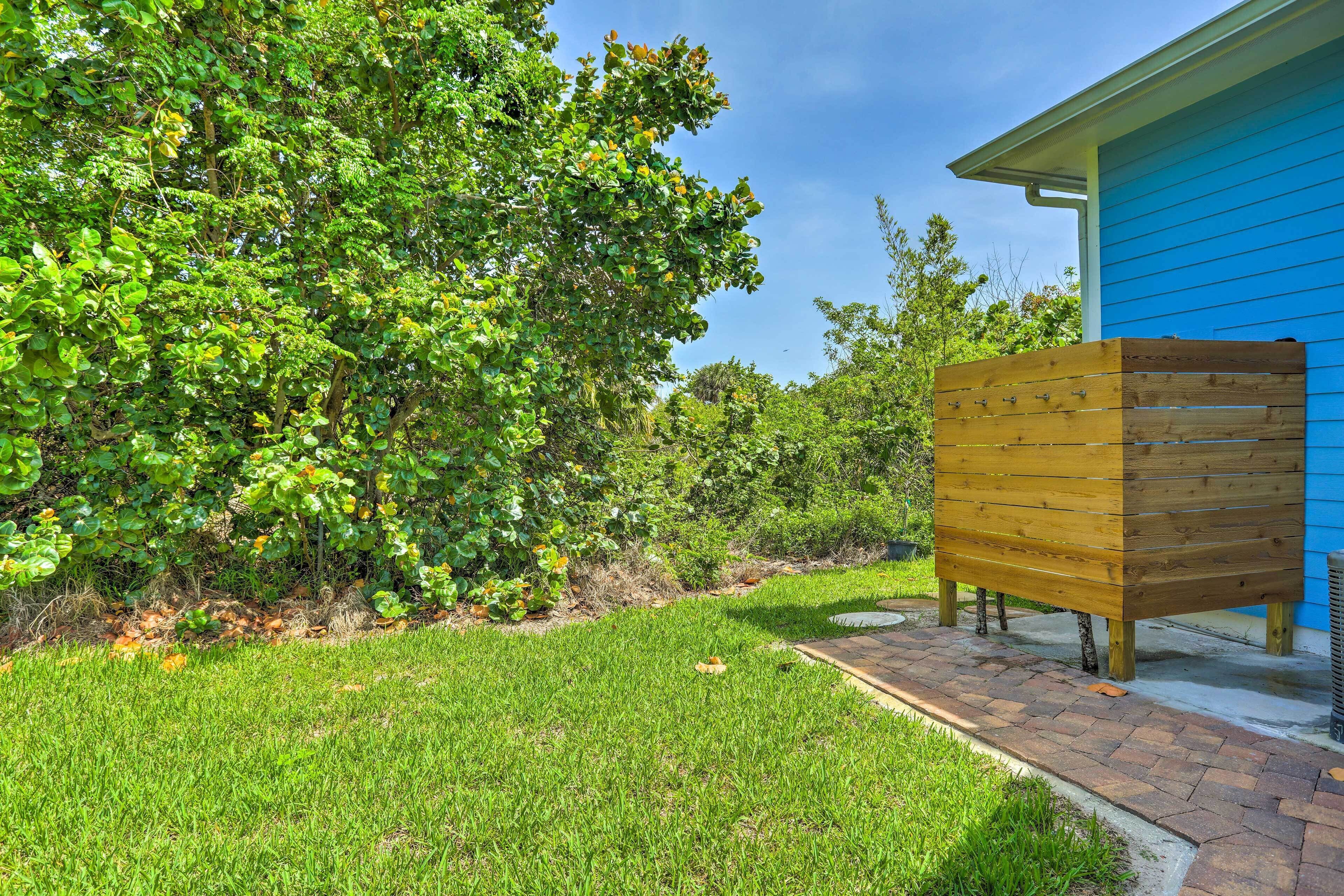 A well-maintained garden with a wooden planter and a blue building.