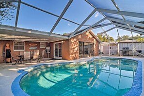 Una piscina interior con techo de cristal, una zona de descanso con sillas y un letrero de Kona Brewing Co.