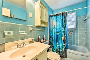 Une salle de bain avec un lavabo, des toilettes et une baignoire.