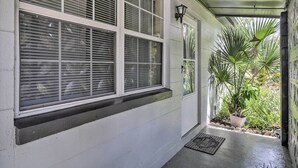 A covered porch with white-framed windows and a potted plant. - Jacksonville Getaway w/ Yard ~ 2 Mi to Beach! (Atlantic Beach)