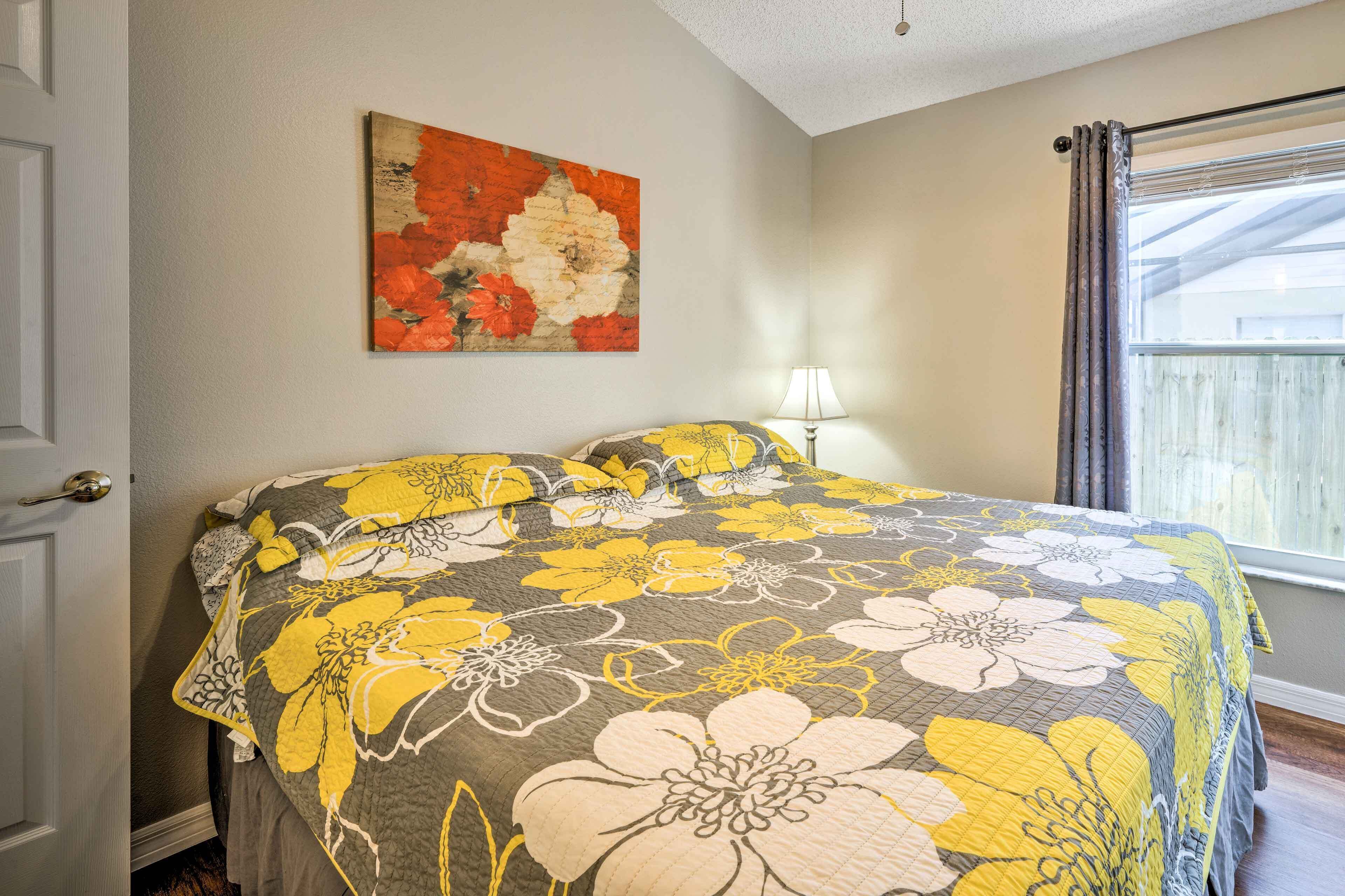 Une chambre à coucher avec un lit, un tableau accroché au mur et une fenêtre avec des rideaux.