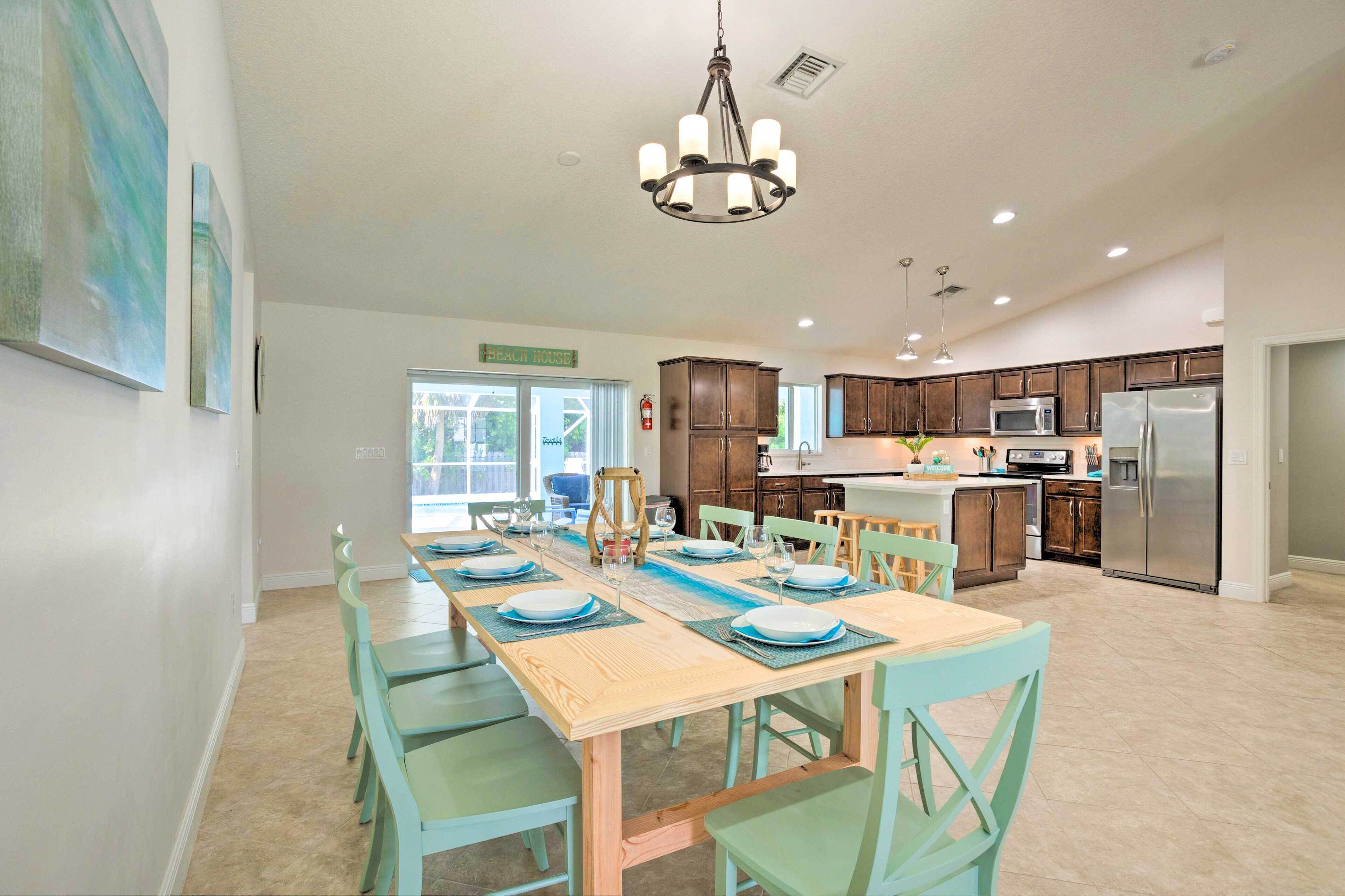 A spacious kitchen with wooden cabinets, a stainless steel refrigerator, and a dining area with a wooden table and green chairs.