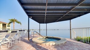 A covered outdoor area with a hot tub, lounge chairs, and a view of the water. - ~ 2 Mi to St Pete Beach! Isla Del Sol Condo (St. Petersburg)