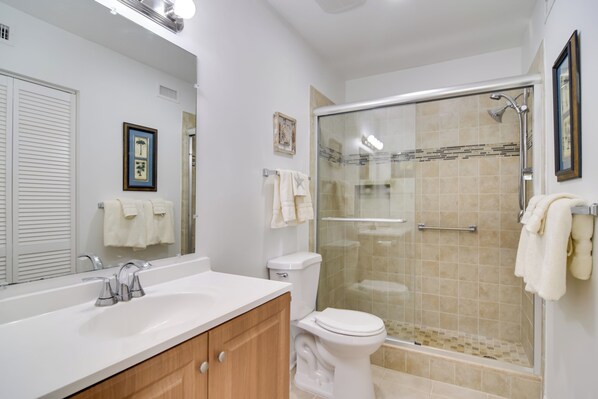 A bathroom with a glass-enclosed shower, a white sink, and a toilet. - ~ 2 Mi to St Pete Beach! Isla Del Sol Condo (St. Petersburg)
