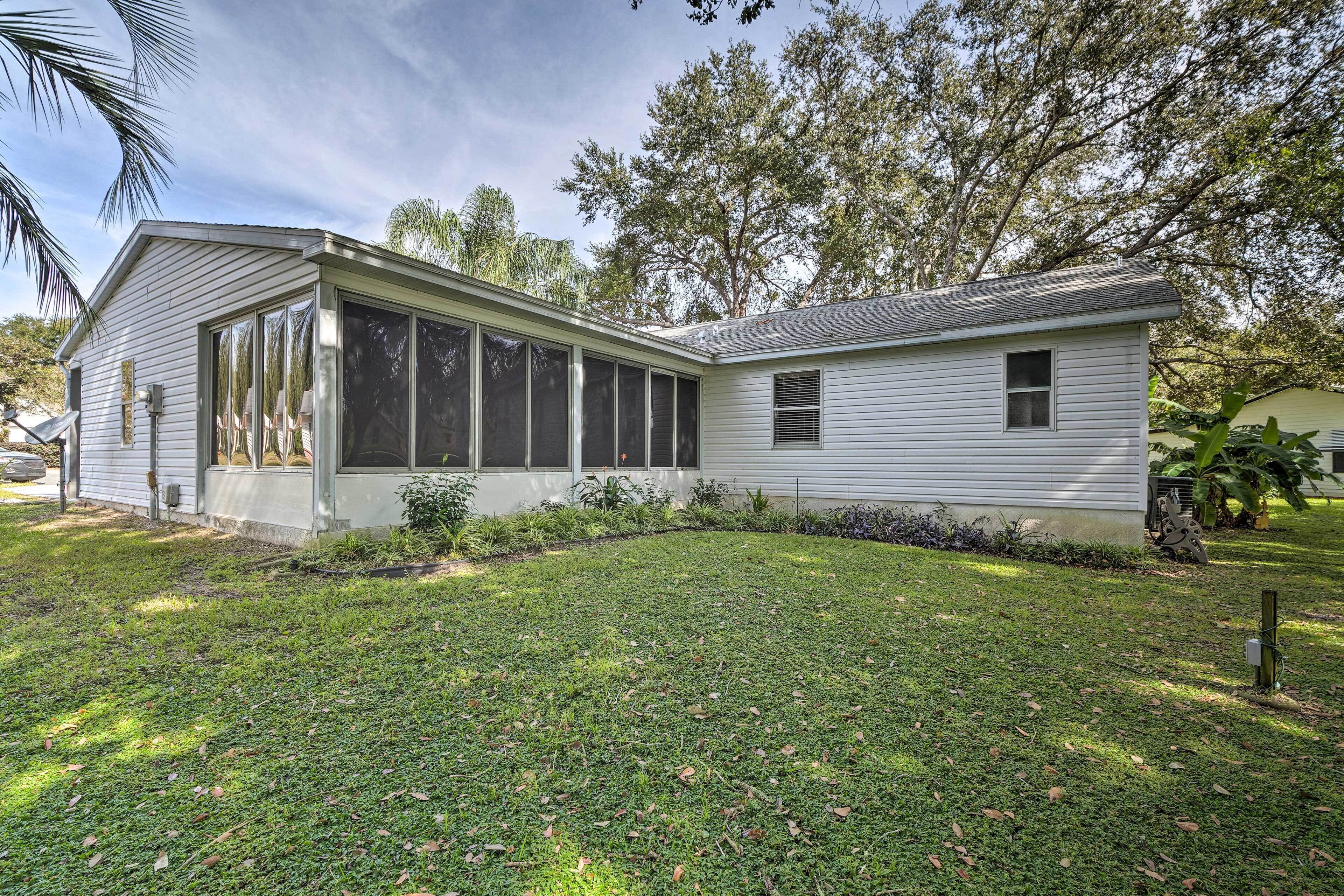 A single-story house with a large windowed porch, a small attached garage, and a well-maintained lawn.