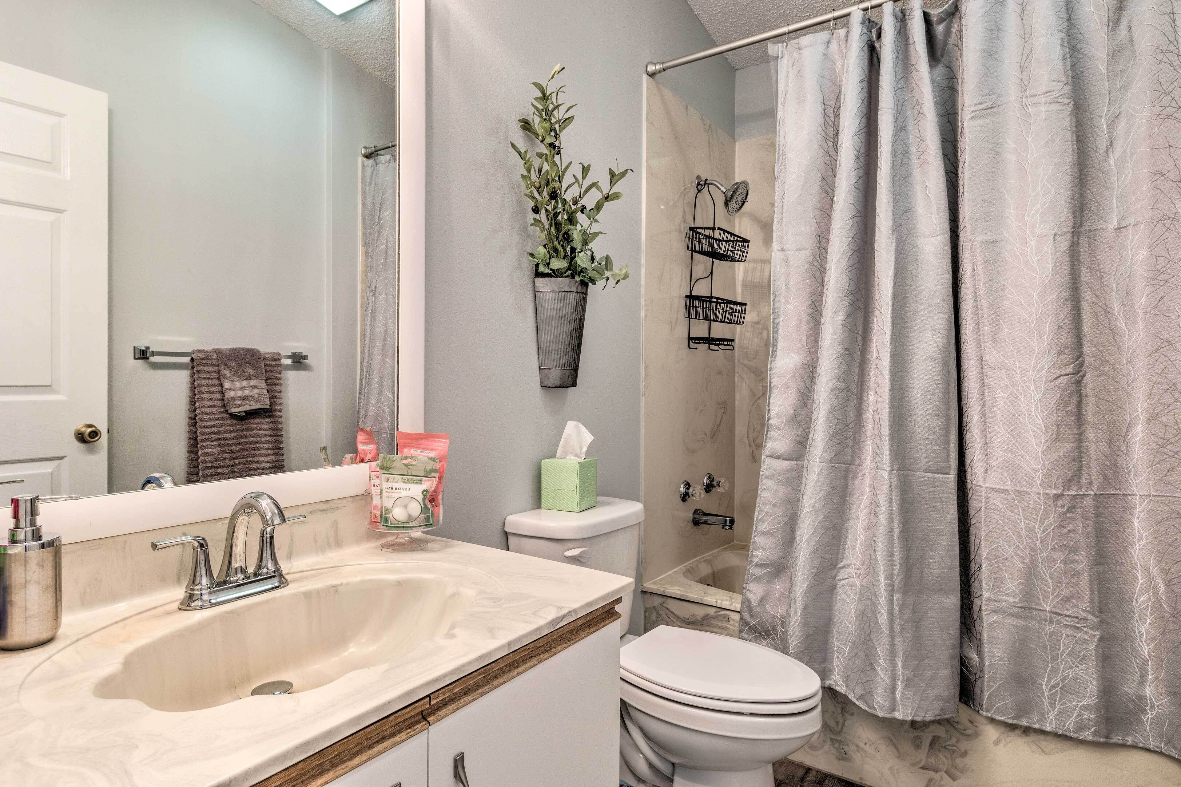 A bathroom with a sink, toilet, and shower curtain.