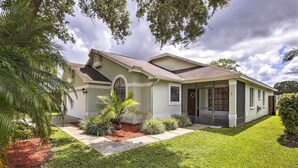 A single-story house with a sloped roof, a front porch, and a well-maintained lawn. - Lakefront Brandon Home w/ Patio & Screened Lanai! (Brandon)