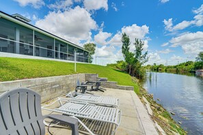 Eine Uferterrasse mit Sitzgelegenheiten und einem Gebäude mit großen Fenstern.
