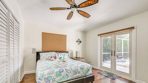 A bedroom with a bed, a ceiling fan, a window, and a door. - Lovely Naples Home: Backyard Oasis w/ Pool! (Naples)