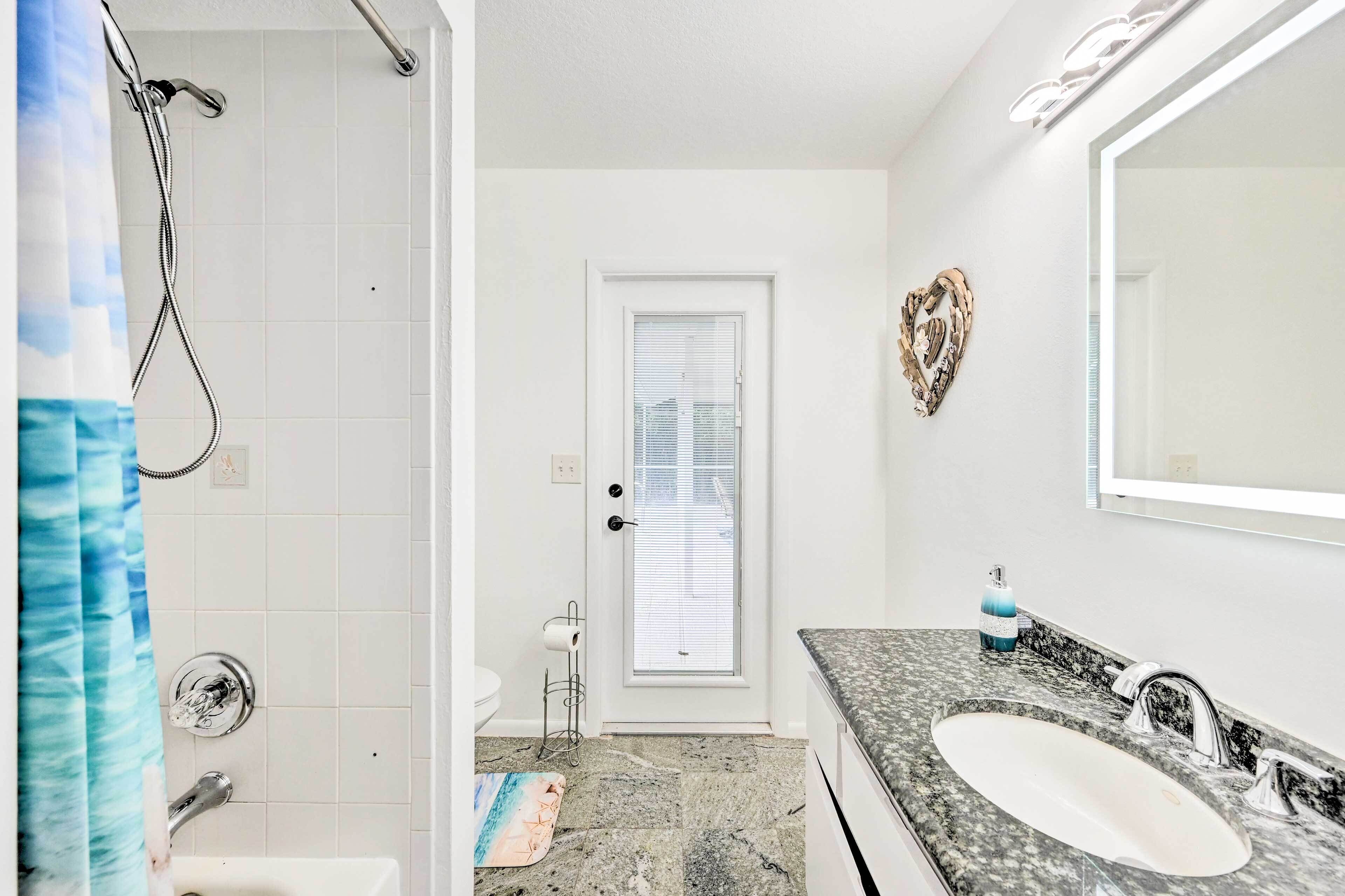 A bathroom with a shower, a sink, and a toilet.
