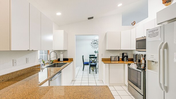 A modern kitchen with white cabinets, granite countertops, a stainless steel oven, and a microwave. - Lovely Naples Home: Backyard Oasis w/ Pool! (Naples)
