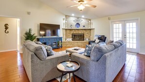 A living room with a gray sofa, a coffee table, a fireplace, and a television. - Private Estate on 10 Acres w/ Pool in Bradenton (Bradenton)