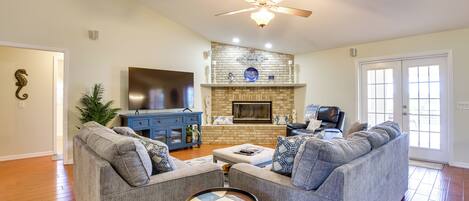 A living room with a gray sofa, a coffee table, a fireplace, and a television.