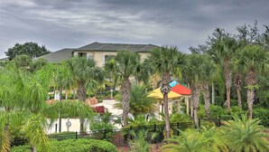 A hotel with a landscaped garden, palm trees, and a building with a grey roof.