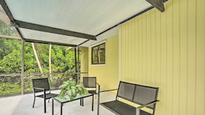 A covered patio area with a table and chairs, surrounded by yellow walls and a window. - Naples Home w/ Private Pool: 6 Mi to Dtwn! (Naples)