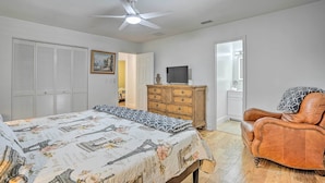 A bedroom with a bed, a wooden dresser, a leather armchair, a ceiling fan, and a television. - Naples Home w/ Private Pool: 6 Mi to Dtwn! (Naples)