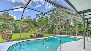 A swimming pool with a glass enclosure, surrounded by lush greenery and a clear sky. - Naples Home w/ Private Pool: 6 Mi to Dtwn! (Naples)