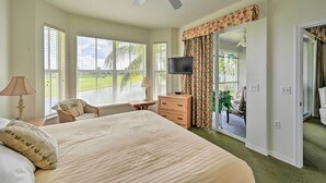A bedroom with a large bed, a ceiling fan, a TV, and a view of the outdoors through the window. - Free Golf Until Oct! Naples Condo w/ Resort Pool (Naples)