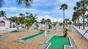 A miniature golf course with multiple green lanes and a mascot statue. - Nettles Island Vacation Rental w/ Resort Amenities (Jensen Beach)
